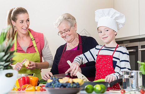 外婆 妈妈和儿子在厨房做饭时聊天家庭转矩厨师女儿奶奶童年孩子食物茄子围裙图片