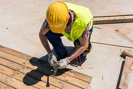 使用锤子的蓝领工人的高角视图阴影劳动者木板建设安全帽地面木头劳动就业头盔图片