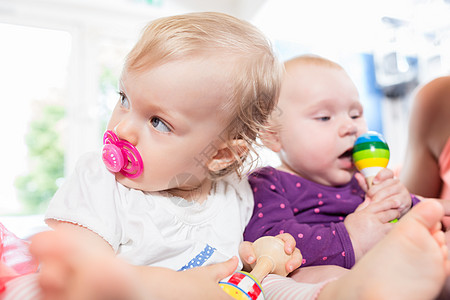 在玩玩具的幼儿组中带有奶嘴的婴儿小组新生儿孩子教养喜悦乐趣孩子们父母游戏母子图片