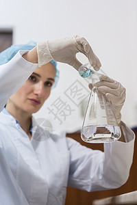 化学家在实验中混合两种液体化学物质手套生产质量低角度检查实验室化妆品女性科学玻璃图片