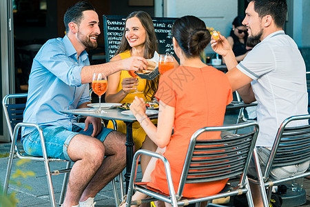 愉快的朋友们以清新夏季饮料为祝酒友谊女性最好的朋友玻璃午餐多样性饮食酒杯椅子闲暇图片