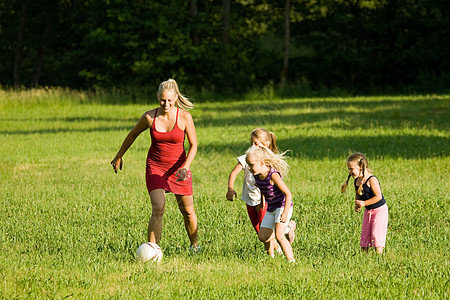 家庭踢足球童年公园妈妈跑步孩子们乐趣阳光活动父亲草地图片