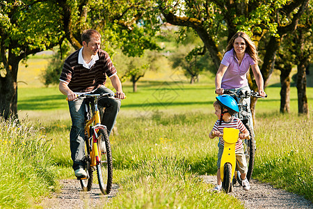 夏季骑自行车的家庭人数父母运动骑术晴天娱乐母亲妈妈闲暇活动阳光图片
