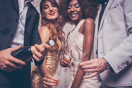男人在俱乐部庆祝时开香槟酒瓶情侣新年裙子金子眼镜快乐女性生日女士潜水员图片