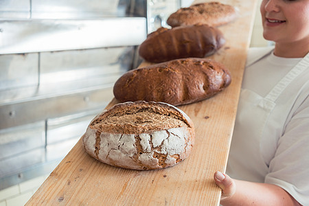 面包店烘烤房的餐桌上新鲜面包包子食物工业烤箱店铺传统工作质量产品女性图片