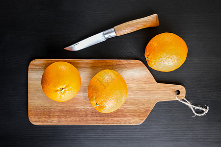 橙子和老旧的传统小刀在切割板上图片