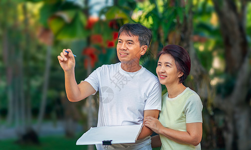 亚洲中年夫妇在后院一起交谈和设计花园计划 家庭环境闲暇微笑男性女性男人幸福丈夫女士建筑师妻子图片