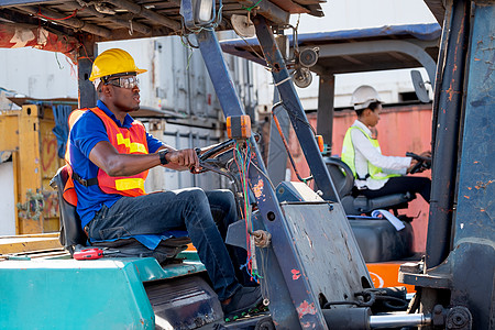 非洲裔美国工头或货运集装箱工人在工作区的女同事旁边驾驶货车 工业支持系统帮助员工绩效理念图片