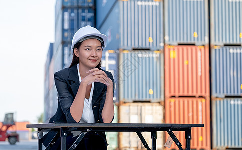 中国女性风格的工厂技术员工程师工人的画像坐在工作区的货物集装箱起重机前 良好支持的概念对工业企业来说是最成功的安全出口控制船运头图片