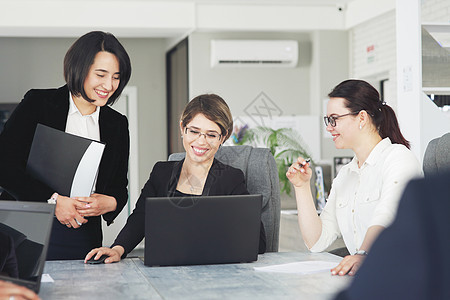 办公室中三名成功的年轻商业女青年 她们一起愉快地为一个项目工作项目商务职业衣领战略工人电脑团队女性技术同事图片