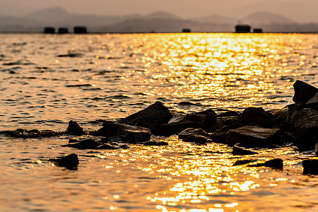 水中的岩石在阳光下反射着黄色的光芒图片