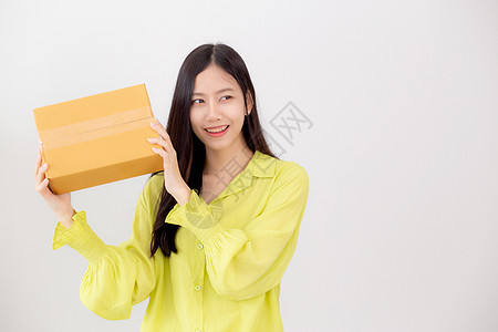 年轻的亚洲女性在家里微笑着拿着惊喜的纸箱 快乐的女性带着兴奋的包裹盒 礼物和礼物 包装送货 在线购物商店和服务理念纸盒船运店铺纸图片