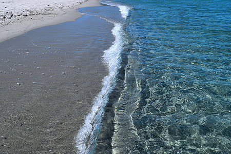 特写意大利撒丁岛科斯塔斯梅拉尔达的清水和白沙子图片
