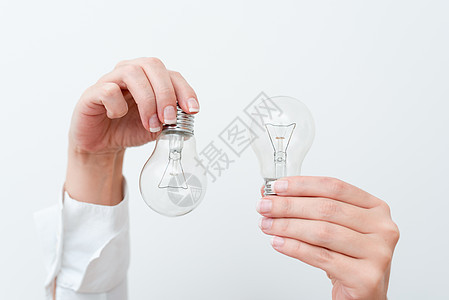 女人手拿着灯提出项目想法 男人手掌展示灯泡和新技术 两个拿着灯泡展示另一种观点电源创造力风暴人士创新环境商业科学电灯人手图片