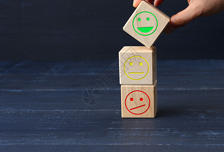 具有不同情绪的木块 从微笑到悲伤和女人的手 评估产品或服务质量的概念评分商业排行符号木头审查顾客用户黄色情感图片