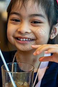 亚洲可爱儿童或小女孩用管子或吸管喝瓶装水或豆奶饮料 吃零食或甜点稻草果汁饮料女性快乐女孩牛奶营养童年玻璃图片