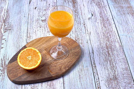 木制桌上的橙汁食物木头饮食玻璃橙子叶子螺旋桌子饮料活力图片