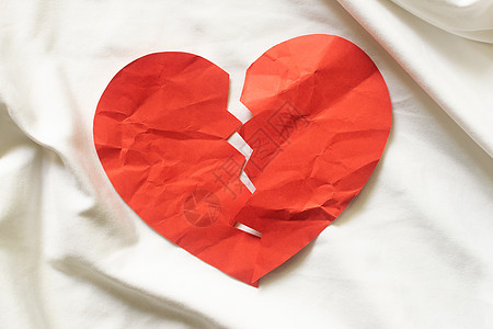 白色纺织品上的碎红纸心 离婚概念图片