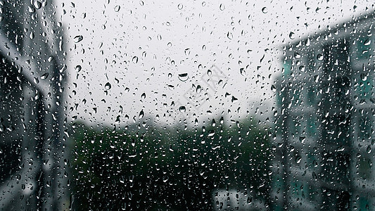 窗玻璃上的雨点暴雨天市中心流动水滴建筑雨季下雨风暴城市季节窗户图片