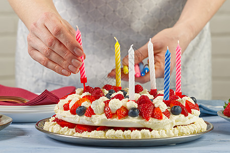 女性手将生日蜡烛添加到自制草莓蛋糕 草莓派和生日蜡烛上乐趣巧克力款待服务员火焰眼镜奶油海绵食物喜悦图片