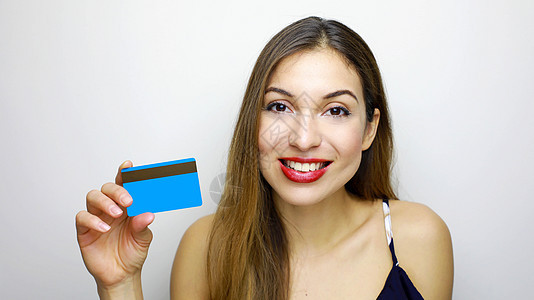 近距离贴近快乐的年轻女性的肖像 她展示了与白背景隔绝的信用卡图片