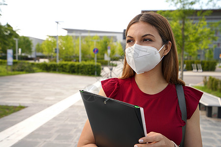 FFFP2KN95脸面罩的漂亮女孩肖像 拿着文件夹看侧侧室外证书员工学生疫苗教育女士封锁商业感染学校图片