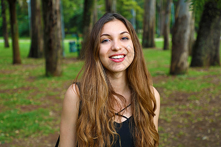 公园里自然的年轻女人的肖像 树在背景上图片