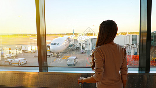 年轻妇女在机场等待她的航班飞行飞机场手提包钱包商业飞机运输旅行女孩游客旅行者图片