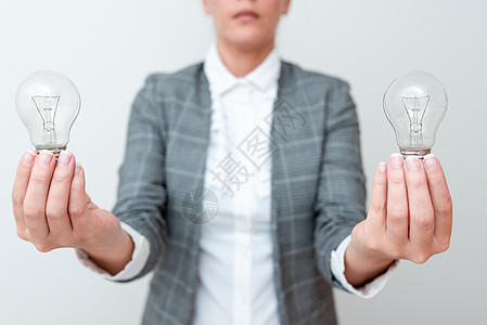女士手持两个灯泡 穿着正式服装 提出项目的另一个想法 女商务人士拿着 2 盏灯 展示最新技术发明环境商业玻璃商务电灯人士设备灯丝图片