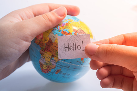 以全球HELLO的文字方式手持纸纸地球概念演讲全球化教育海报行星英语生活世界图片