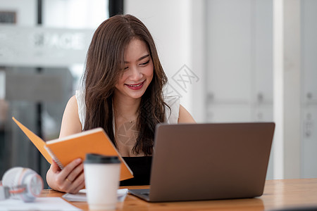 照片中 快乐迷人的女性使用笔记本电脑参加在线会议 商务女性在家工作图片