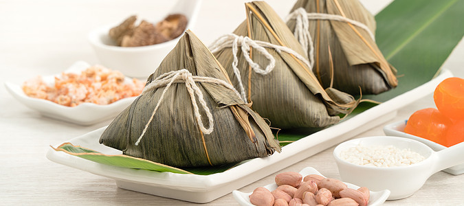 松子 龙船节的米面铺在有成分的明亮木制桌布上传统桌子花生饺子文化叶子木头食物庆典竹子图片