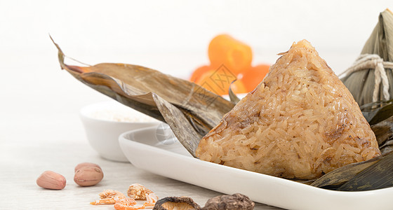 松子 龙船节的米面铺在有成分的明亮木制桌布上盘子木头叶子桌子传统竹子蛋黄饺子花生文化图片