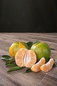 黑色木制桌底的绿色橘子柑橘橙色收成市场农业团体饮食热带叶子篮子桌子农场图片