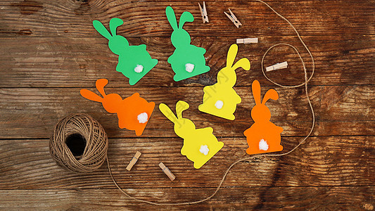 复活节兔子在木制背景上用纸做成 为 easte 创建一个装饰假期野兔风格乡村耳朵庆典工具工艺绳索木头图片
