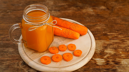 明亮橙红胡萝卜汁 在木本底的玻璃罐子里生物美食橙子木头饮料乡村食物蔬菜萝卜水壶图片