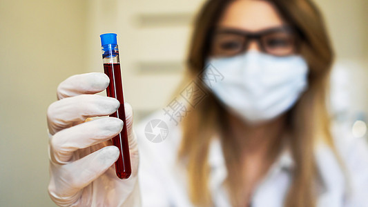 近距离接近年轻女科学家 她拿着血液样本的测试管探测实验室手套医院化学品药品管子化学生物女士图片