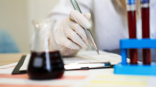 在化验室与血液样本一起工作的妇女 特查疾病生物清单技术女士化学医院助手标本管子图片