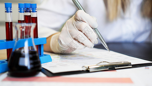在化验室与血液样本一起工作的妇女 特查临床测试报告标本药品医院女性化学管子写作图片