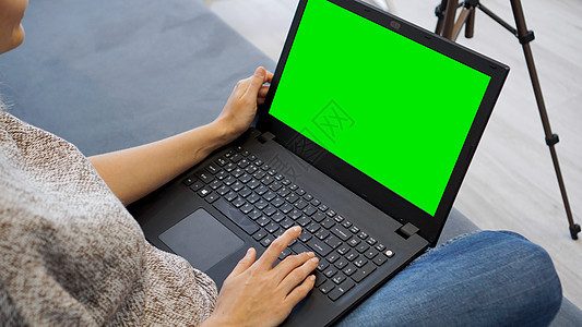 妇女使用绿色屏幕的笔记本电脑 妇女在笔记本电脑键盘上打字手指木板桌子钥匙工作技术互联网网络自由职业者女性图片