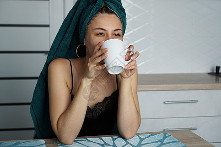 美丽的女人坐在厨房里 喝咖啡和一杯咖啡假期闲暇女士女性毛巾纺织品卫生思考女孩香气图片