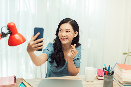 快乐的亚洲女孩在视频电话上微笑 在智能手机上自拍女性照片学生女士技术学习教育图片