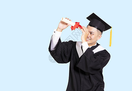 持有和通过文凭寻找毕业证书的年轻男性毕业生图片