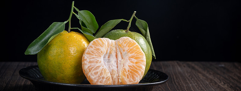 黑色木制桌底的绿色橘子柑橘橙色篮子桌子水果食物团体热带饮食农业市场收成图片