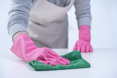 围裙的年轻女管家戴着粉色手套清洁桌子 预防病毒感染的概念 家政服务 特写卫生服务女佣家务职员清洁工工作橡皮女士守门员图片