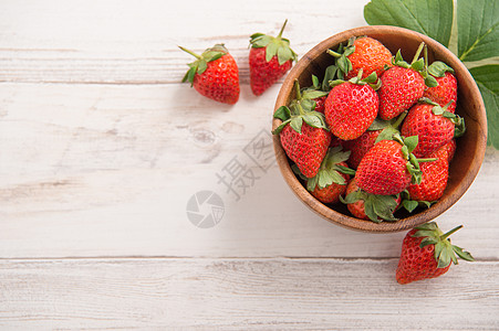 一碗美丽而美味的草莓 被隔绝在浅木质背景上 特写 顶视 复制空间上水果宏观植物灰蓝色收成木头太阳食物叶子阳光图片