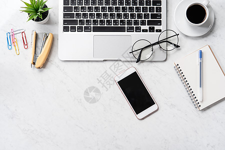 平板桌面风格化的大理石办公桌 配有智能手机 笔记本电脑 眼镜和咖啡 工作区设计 模型 顶视图 平板 复制空间 特写商业高架日记键盘小样作背景