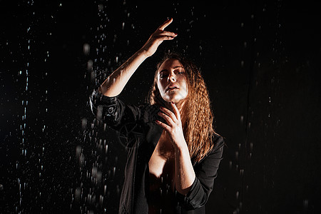 在雨滴下 穿黑夹克的湿润美丽的女人浴室身体女士天气外套成人街道黑发温泉帽子图片