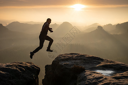 日落时 人类在天上跳跃冒险乐趣悬崖登山逆境运动员活动荒野危险极限图片