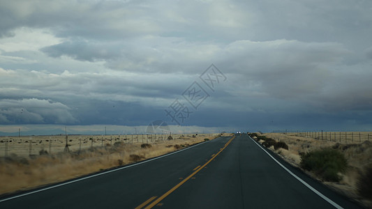 驾驶汽车 在美国加利福尼亚州进行公路旅行 从汽车上看 在美国搭便车旅行 暴雨前的高速公路 山脉和多云的戏剧性天空 美国风景道 乘图片